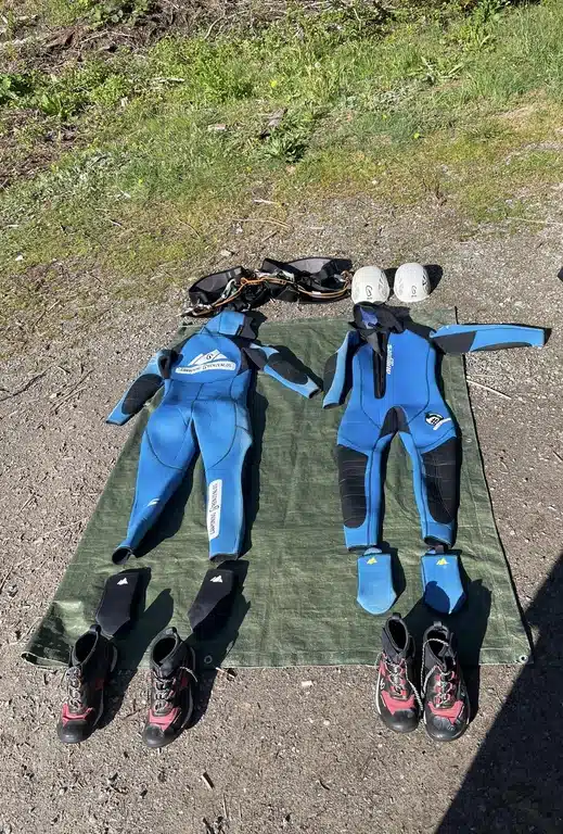 Die komplette bereitgestellte Schuzzausrüstung mit Helm, Anzug, Socken, Schuhe und Gürtel | Canyoning-Grenzenlos